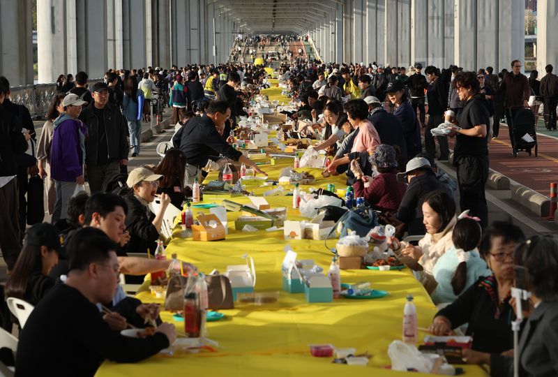 [서울=뉴시스] 김명년 기자 = 25일 서울 잠수교에서 열린 차 없는 잠수교 뚜벅뚜벅 축제의 마지막 행사인 ‘잠수교 치킨데이’에서 시민들이 다양한 브랜드의 치킨을 맛보고 있다. 잠수교는 26일부터 차량 통행이 전면 통제되며 한강 보행전용교 조성을 위한 공사에 들어간다. 2026.10.25. kmn@newsis.com