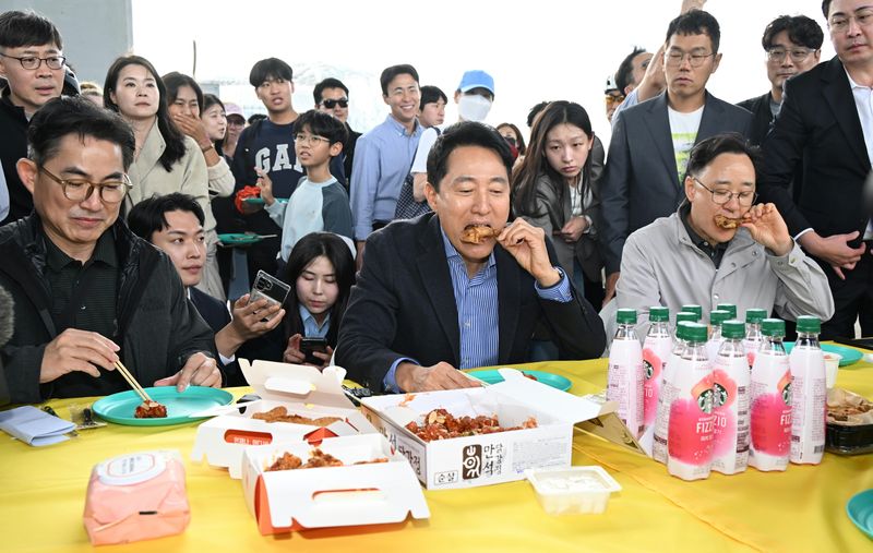 [서울=뉴시스] 오세훈 서울시장이 25일 오후 잠수교에서 열린 '잠수교 치킨데이'에서 치킨을 시식하고 있다. (사진=서울시 제공) 2026.10.25. photo@newsis.com *재판매 및 DB 금지