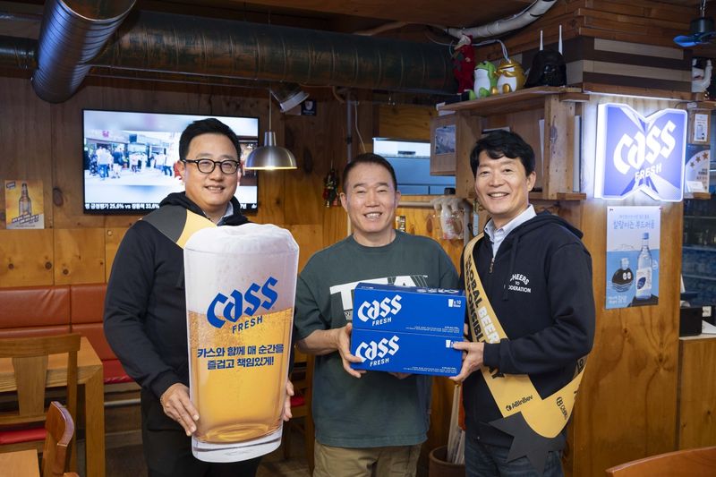 최근 서울의 한 주점에서 구자범 오비맥주 수석 부사장(왼쪽 첫번째)과 오비맥주 김병훈 영업 부사장(오른쪽 첫번째)이 점주에게 책임음주 문구가 담긴 맥주잔을 전달하고 기념사진을 찍고 있다. 오비맥주 제공