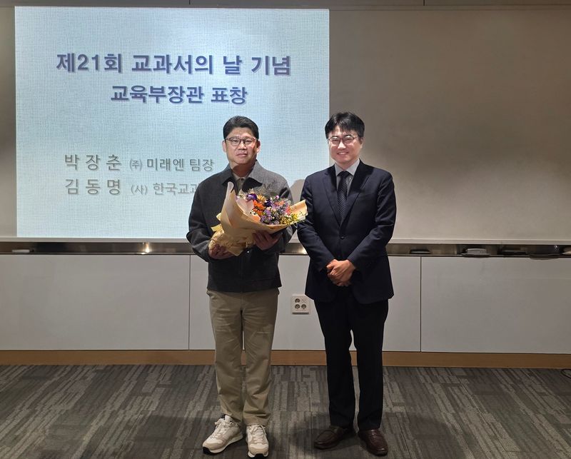 지난 24일 열린 제21회 '교과서의 날' 기념식에서 교육부장관상을 수상한 박장춘 미래엔 교과서사업팀 수석팀장(왼쪽)이 이상범 교육부 교육콘텐츠정책과장과 기념 촬영을 하고 있다. 미래엔 제공