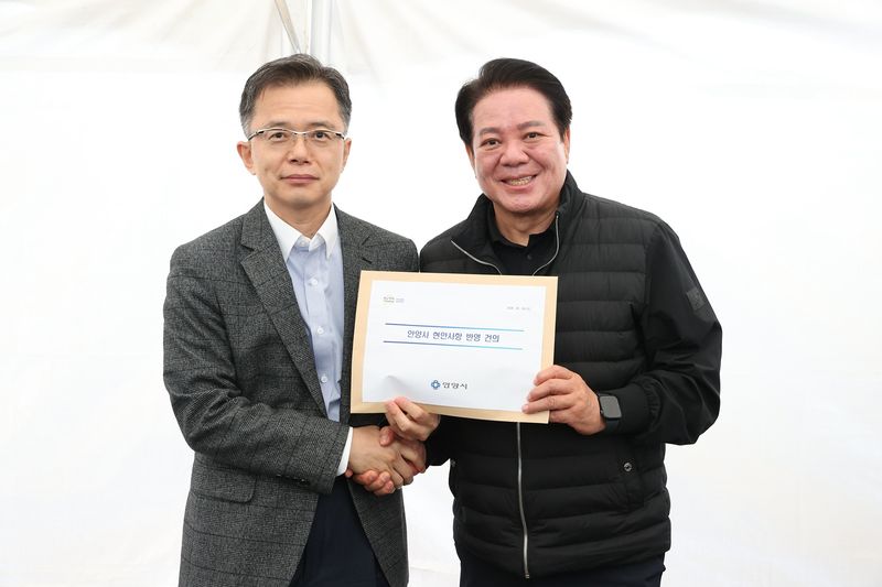 최대호 안양시장(오른쪽)이 김석기 국토부 건설정책국장에게 박달스마트시티 조성사업의 개발제한구역 해제와 위례과천선 안양권 연장사업의 국가계획 반영을 요청하는 건의서를 전달했다. 안양시 제공