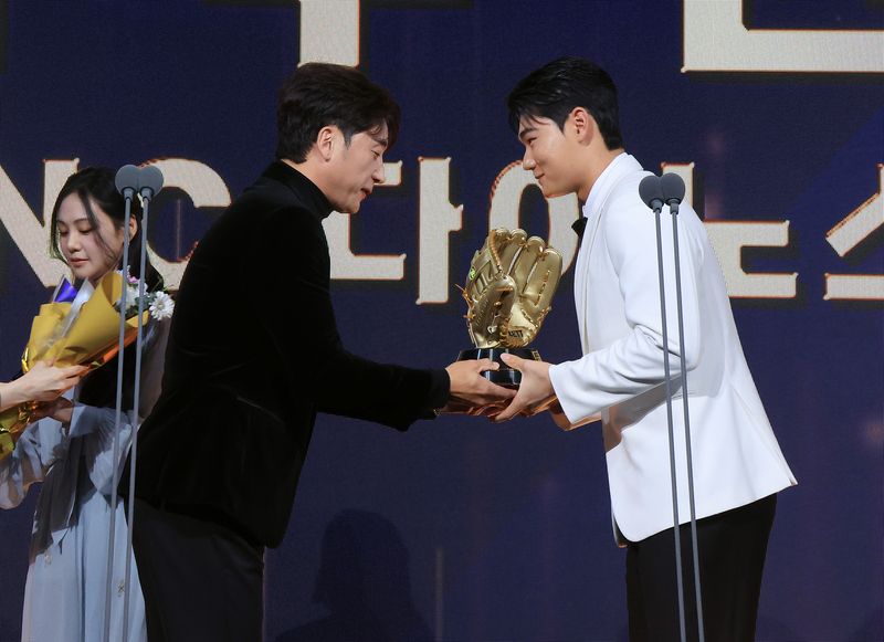9일 오후 서울 송파구 롯데호텔 월드에서 열린 프로야구 2025 신한 SOL뱅크 골든글러브 시상식에서 유격수 부문 골든글러브를 수상한 NC 김주원이 이택근 해설위원에게 트로피를 받고 있다. 2025.12.9 ⓒ 뉴스1 김진환 기자