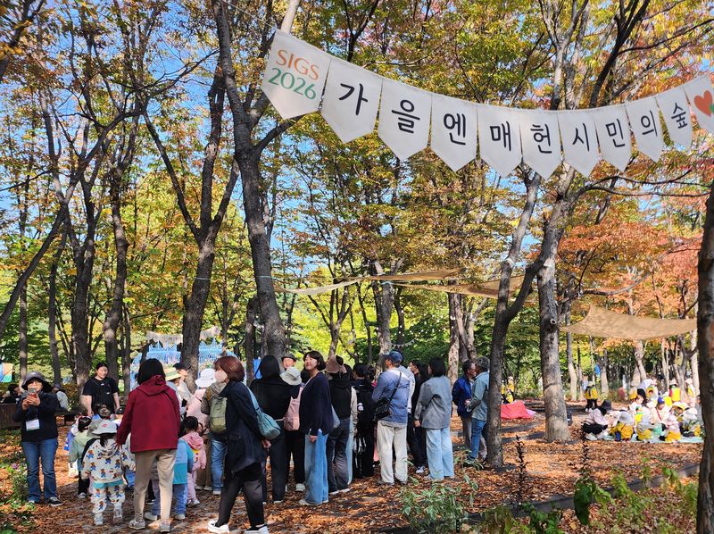 '2026 서울국제정원박람회' 기간 중 매헌시민의 숲에서 진행된 도슨트 해설 프로그램에 참여한 시민들이 해설사의 설명을 듣고 있다. 서울시 제공