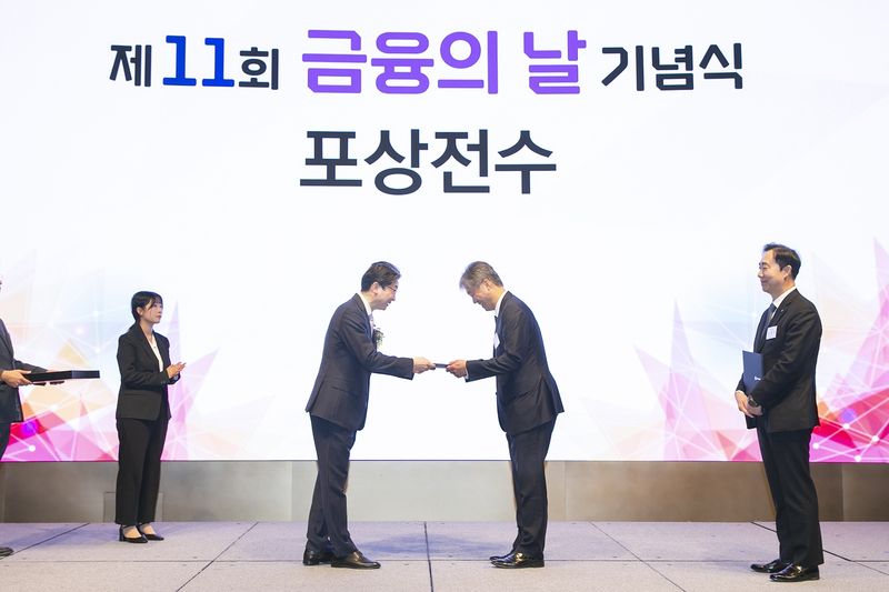 이억원 금융위원회 위원장(가운데 왼쪽)이 케이뱅크 최우형 은행장(가운데 오른쪽)에게 27일 서울 중구 웨스틴 조선 호텔에서 열린 '제11회 금융의 날' 기념식에서 포용금융부문 금융위원장상을 수여하고 있다. 케이뱅크 제공