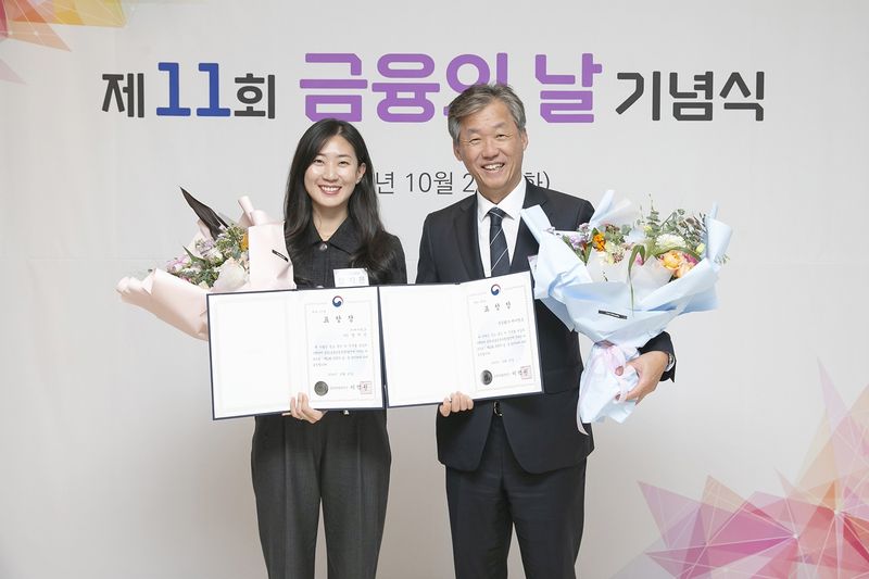 최우형 케이뱅크 은행장(오른쪽)과 장지은 케이뱅크 매니저가 27일 서울 중구 웨스틴 조선 호텔에서 열린 '제11회 금융의 날' 기념식에서 포용금융부문 수상 후 기념촬영을 하고 있다. 케이뱅크 제공