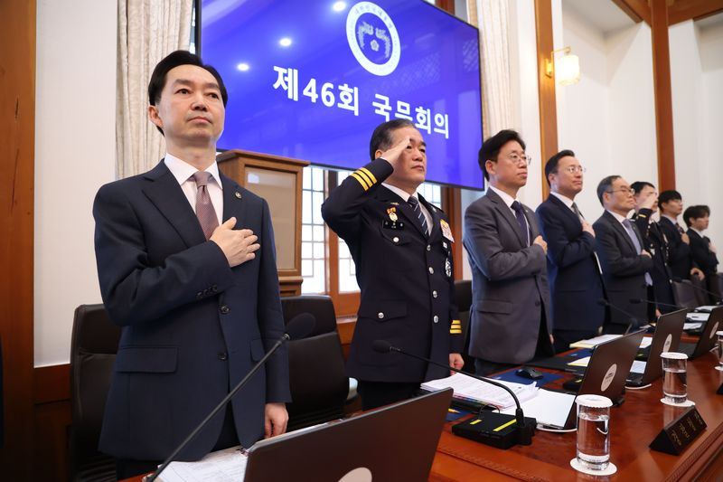 김지용 중대범죄수사청장(왼쪽부터)과 김종철 경찰청장 직무대행 등이 27일 이재명 대통령 주재로 청와대에서 열린 국무회의에 참석, 국기에 대한 경례를 하고 있다. 연합뉴스