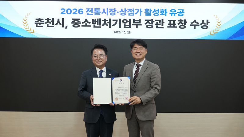 육동한 춘천시장과 서종필 강원지방중소벤처기업청장(사진 왼쪽부터)이 28일 춘천시청 접견실에서 열린 2026 전통시장·상점가 활성화 유공 중소벤처기업부 장관 표창 전수식에서 기념촬영을 하고 있다. 춘천시 제공