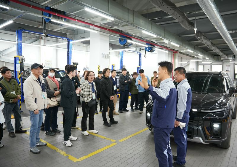 KGM 관계자가 지난 28일 광역서비스센터 군포사업장에서 열린 'KGM 서비스 고객 초청 행사'에서 자동차 무상 점검과 차량 관리 방법 등을 소개하고 있다. KGM 제공