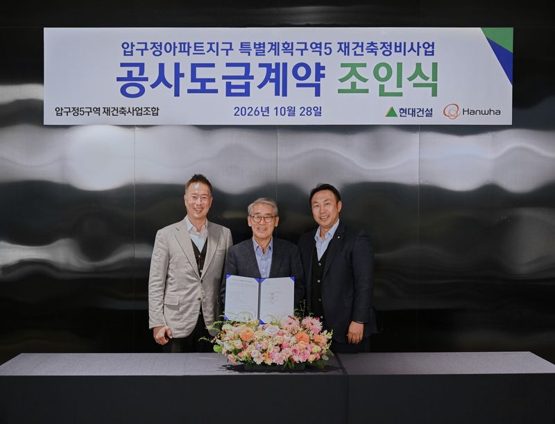 구정5구역 안양호 조합장(가운데)과 신국현 현대건설 상무(왼쪽), 우재희 한화 상무(오른쪽)가 29일 공사도급계약을 체결하고 기념사진을 촬영하고 있다. 현대건설.