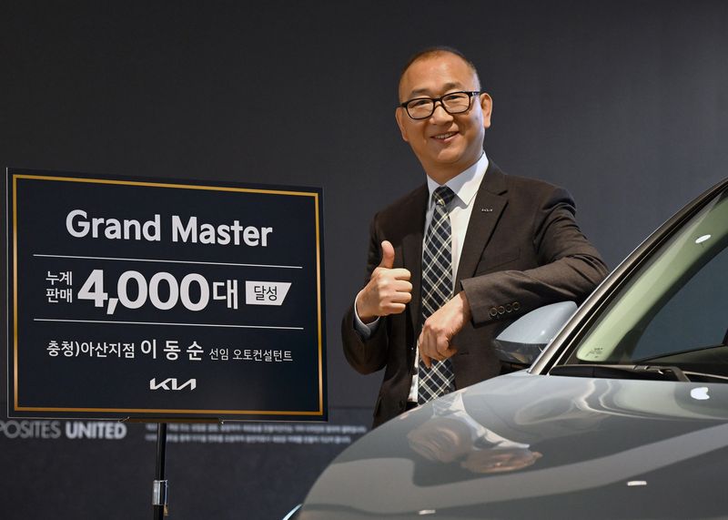 누계 판매 대수 4천대를 달성해 ‘그랜드 마스터(Grand Master)’에 등극한 충청 아산지점 이동순 선임 오토컨설턴트가 기념촬영을 하고 있다. 기아 제공